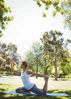 Fit woman doing yoga in the park