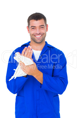 Male mechanic wiping hands with cloth