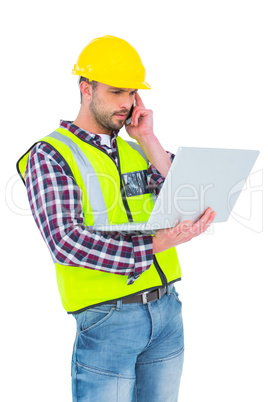 Handyman on the phone holding laptop