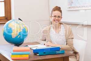Teacher in classroom with globe