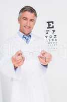 Optometrist holding eyeglasses out