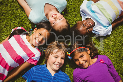 Portrait of children lying on grass at park