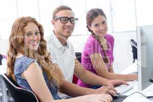 Students smiling at camera in computer class