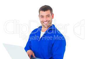 Portrait of smiling male mechanic using laptop