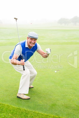 Happy golfer cheering on putting green