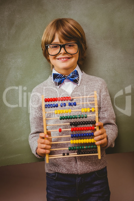 Boy holding abacus in front of blackboard