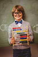 Boy holding abacus in front of blackboard