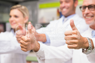 Positive co-workers standing with thumbs up
