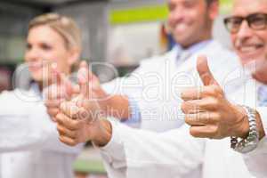 Positive co-workers standing with thumbs up