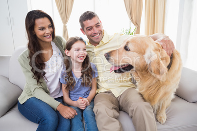 Family looking at Golden Retriever on sofa