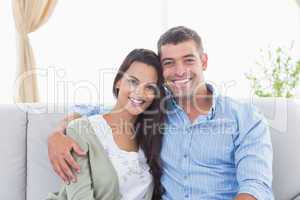 Happy loving couple sitting on sofa