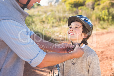 Father clipping on sons helmet
