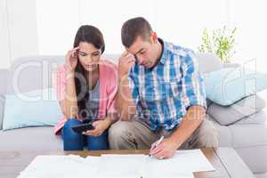 Worried couple calculating home finances