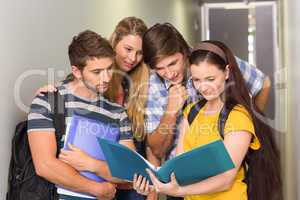 Students holding folders at college corridor