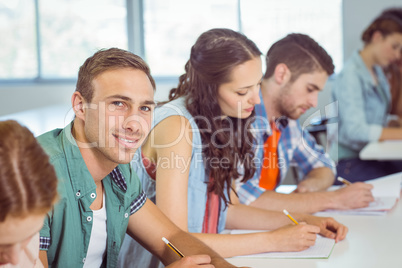 Fashion student smiling at camera in class