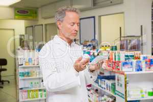 Pharmacist reading prescription and holding medicine