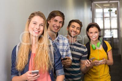 Students with cellphones at college corridor