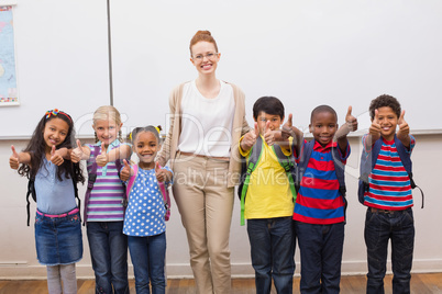 Teacher and pupils smiling at camera in classroom