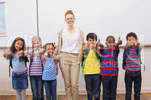 Teacher and pupils smiling at camera in classroom