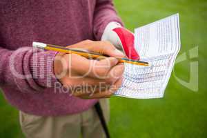 Golfer writing his points in paper
