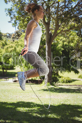 Fit woman skipping in the park
