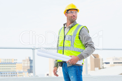 Architect holding rolled up blueprints outdoors