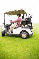 Golfer driving in his golf buggy