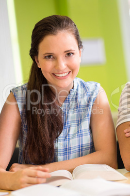 Female student reading book in library