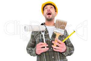 Screaming manual worker holding various tools