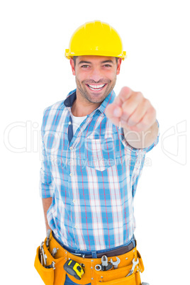 Portrait of smiling handyman pointing at you