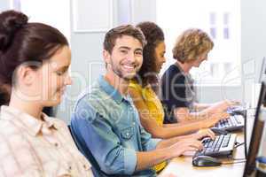 Student smiling at camera in computer class