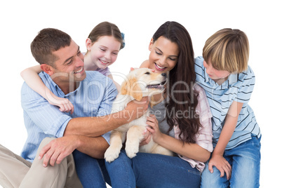 Family of four playing with dog