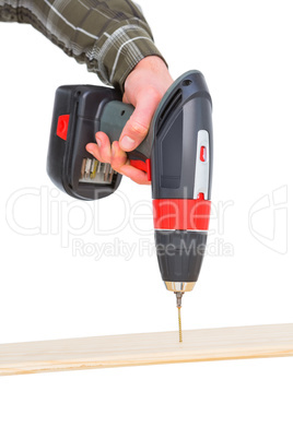 Carpenter drilling hole in plank in office
