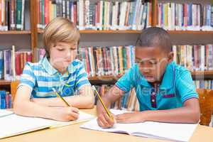 Cute pupils drawing in library