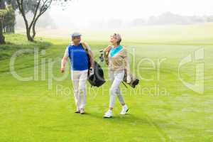 Golfing couple walking on the putting green