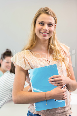 Female student holding folder in college