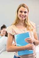 Female student holding folder in college