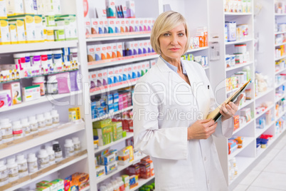 Serious pharmacist holding clipboard