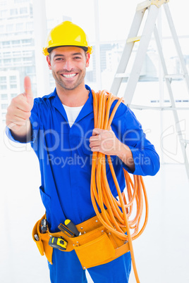 Male technician with wire roll gesturing thumbs up