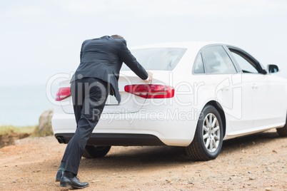 Businessman pushing his car