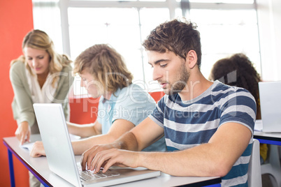 Student using laptop in classroom