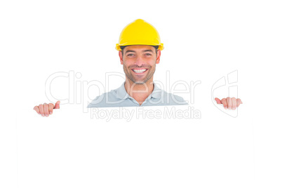 Happy handyman holding placard on white background