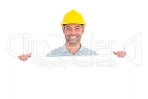 Happy handyman holding placard on white background