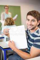 Happy male student holding paper