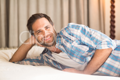 Handsome man relaxing on his bed