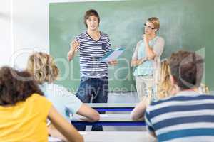 Student explaining notes besides teacher in class