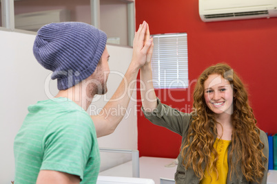 Casual businessman and woman high fiving