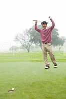 Excited golfer cheering on putting green