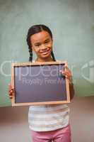 Portrait of cute little girl holding school slate
