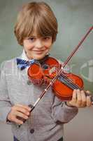 Portrait of cute little boy playing violin